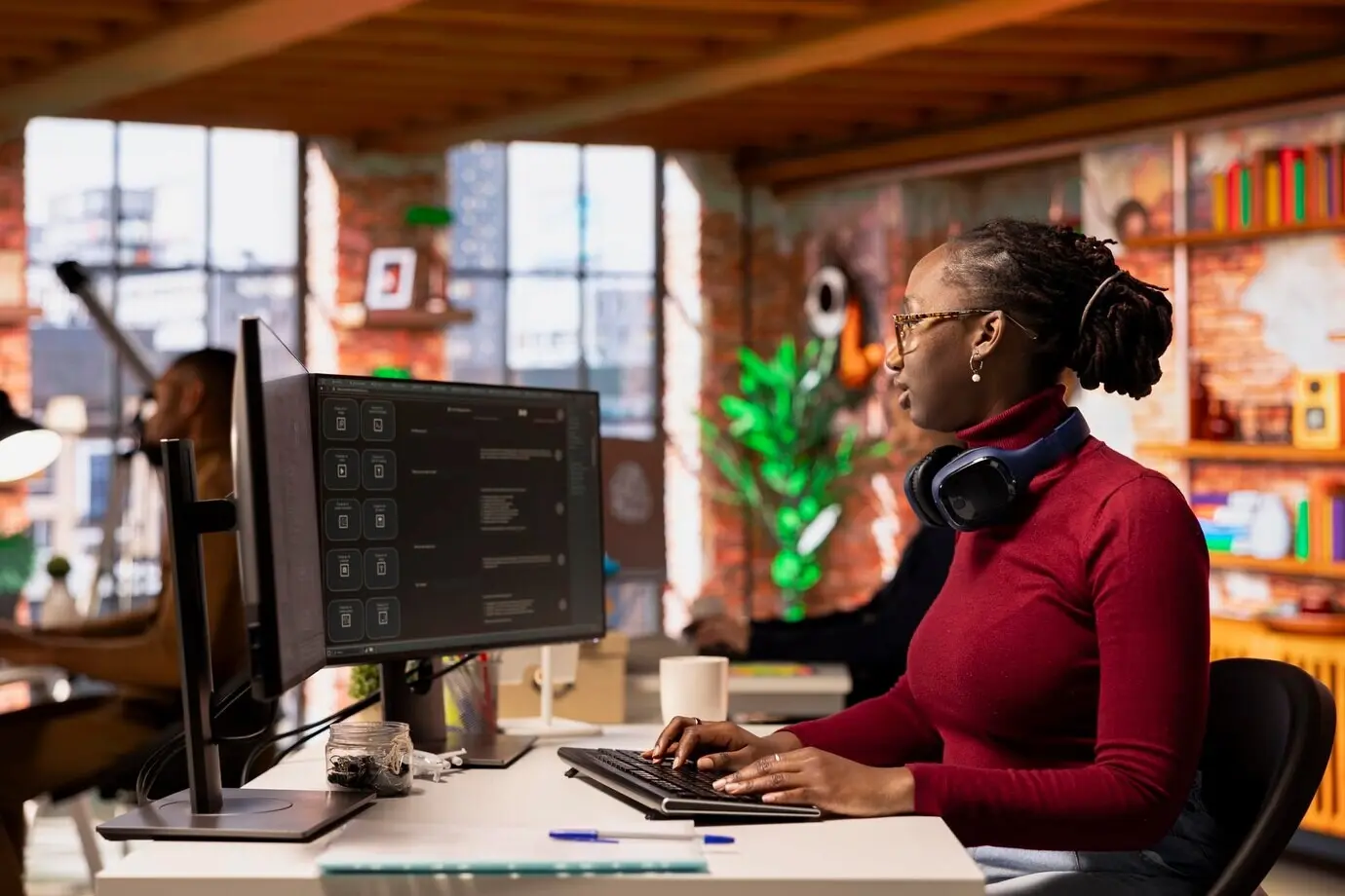 A startup worker consulting an AI LLM chatbot for help with coding tasks.